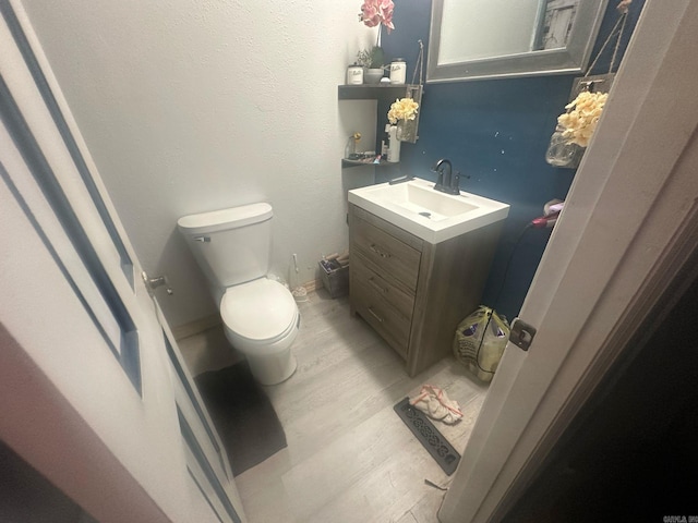 bathroom featuring vanity, wood finished floors, and toilet