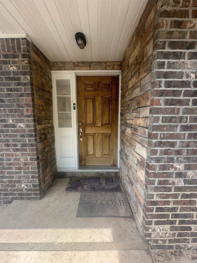 view of exterior entry featuring brick siding