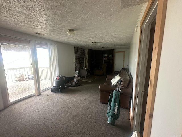 living area with carpet, a textured ceiling, and visible vents