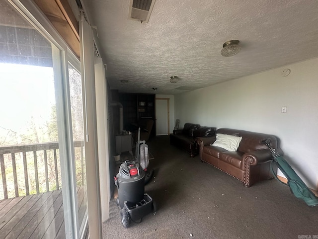 living room with carpet floors, a textured ceiling, and visible vents