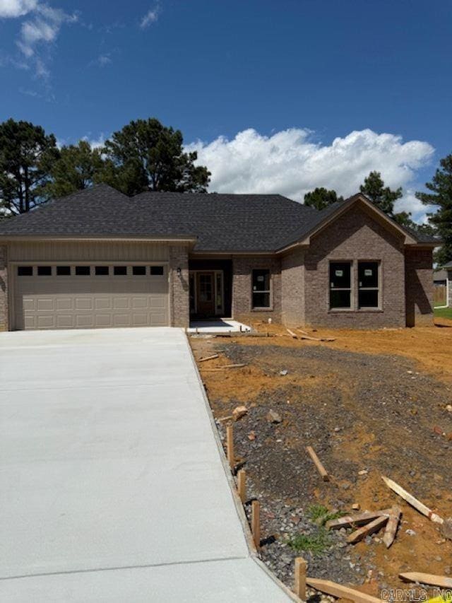 single story home with an attached garage, driveway, and brick siding