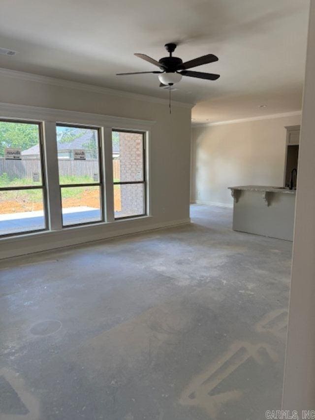 unfurnished living room with crown molding, a ceiling fan, and concrete floors