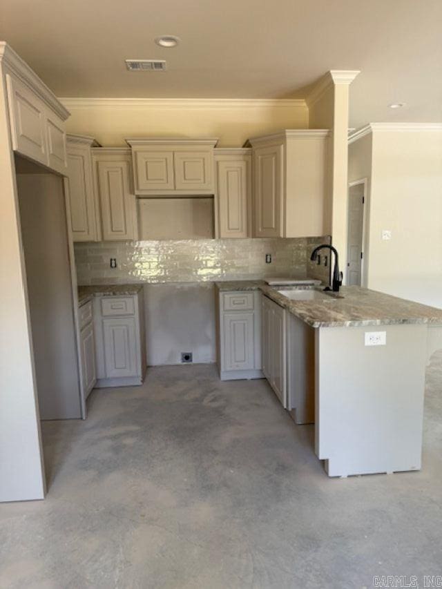 kitchen with visible vents, a sink, backsplash, and ornamental molding