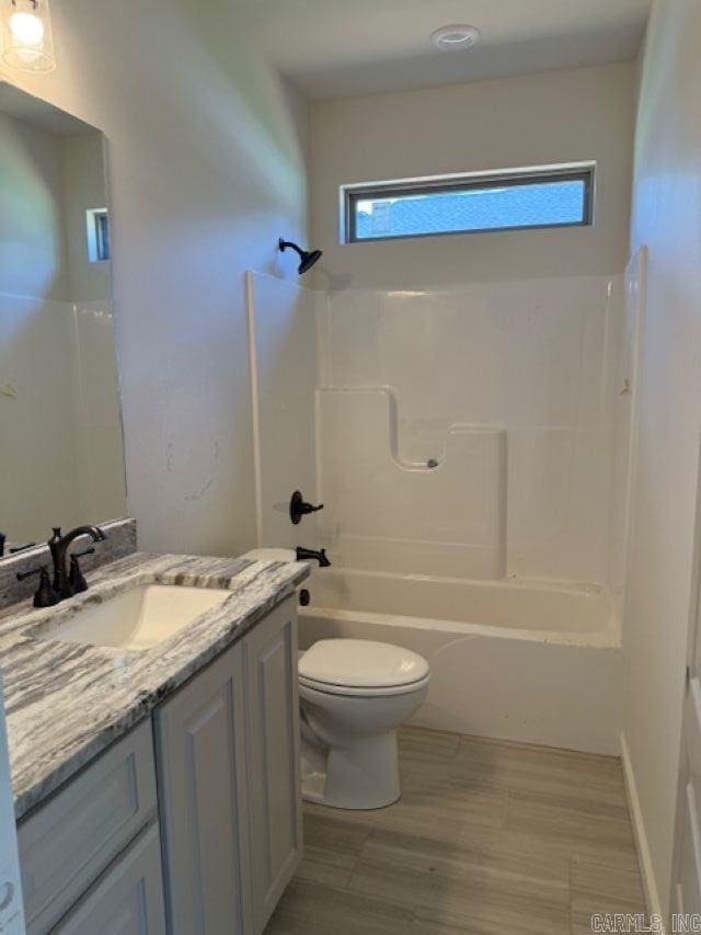 bathroom with toilet, bathing tub / shower combination, a wealth of natural light, and vanity