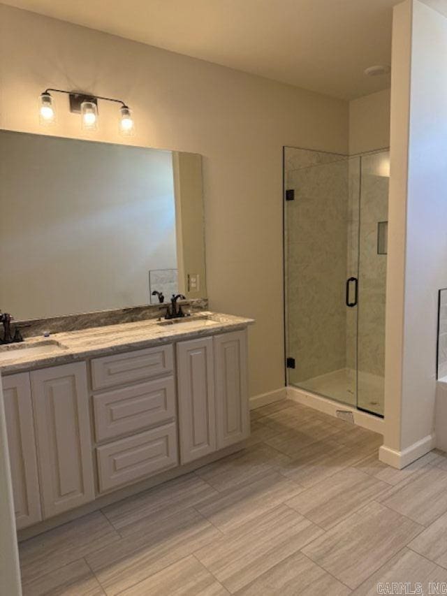 full bathroom featuring a sink, a bath, a shower stall, and double vanity