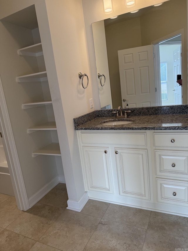 bathroom featuring vanity, baseboards, and tile patterned floors