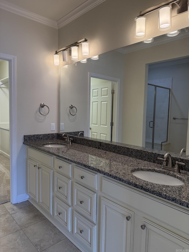 full bathroom with crown molding, double vanity, a sink, and a stall shower