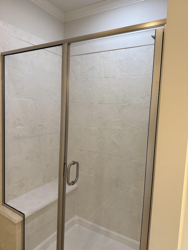 bathroom featuring ornamental molding and a shower stall