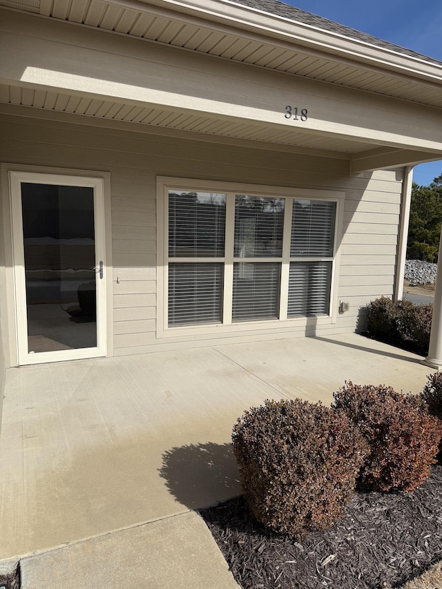 view of exterior entry with a patio