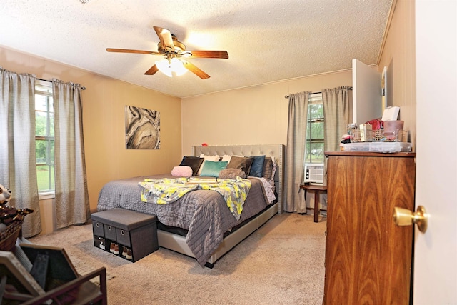bedroom with a textured ceiling, light colored carpet, and multiple windows