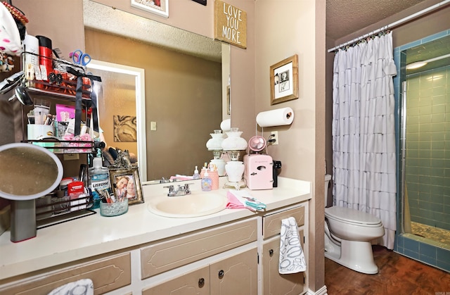 bathroom with vanity, a textured ceiling, a stall shower, and toilet