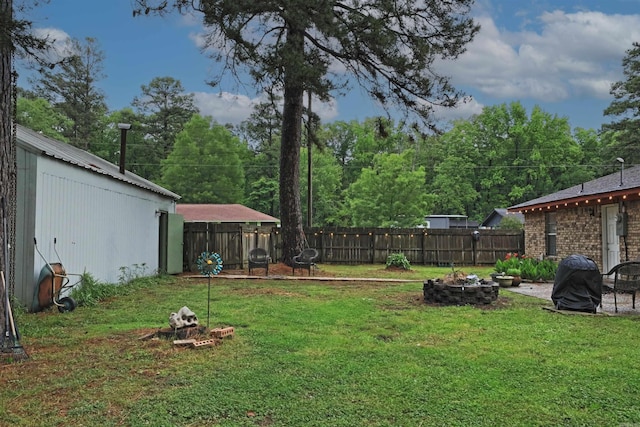 view of yard featuring a fenced backyard and a fire pit