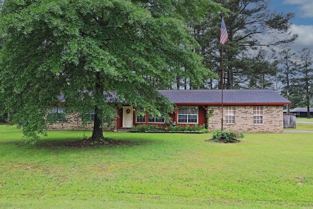 ranch-style home featuring brick siding and a front lawn