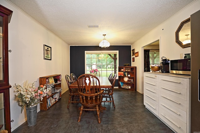 dining room featuring crown molding, an inviting chandelier, a textured ceiling, and visible vents