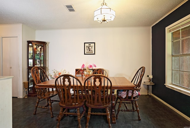 dining room featuring an inviting chandelier, a textured ceiling, crown molding, and visible vents