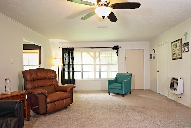 living area featuring carpet floors, heating unit, ornamental molding, and visible vents