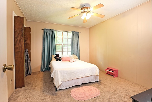 bedroom with carpet floors, a ceiling fan, and a textured ceiling
