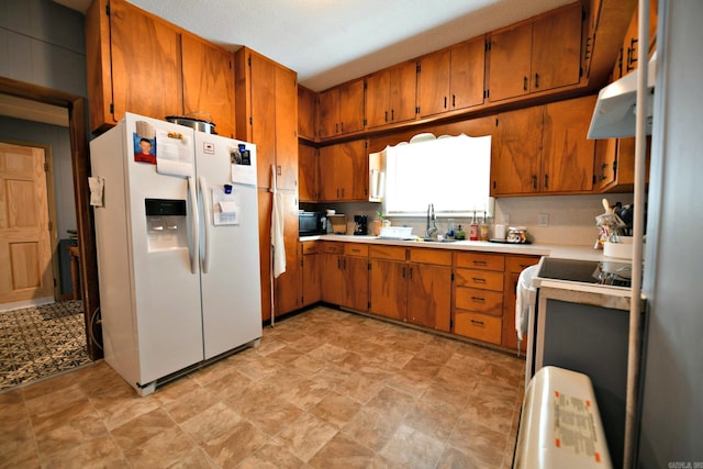 kitchen featuring brown cabinetry, light countertops, extractor fan, and white fridge with ice dispenser