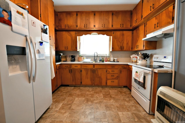 kitchen featuring brown cabinets, a sink, heating unit, under cabinet range hood, and white appliances