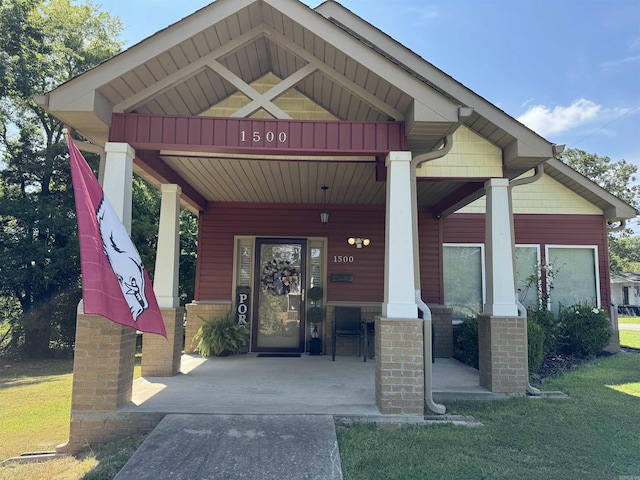 property entrance with covered porch and a yard