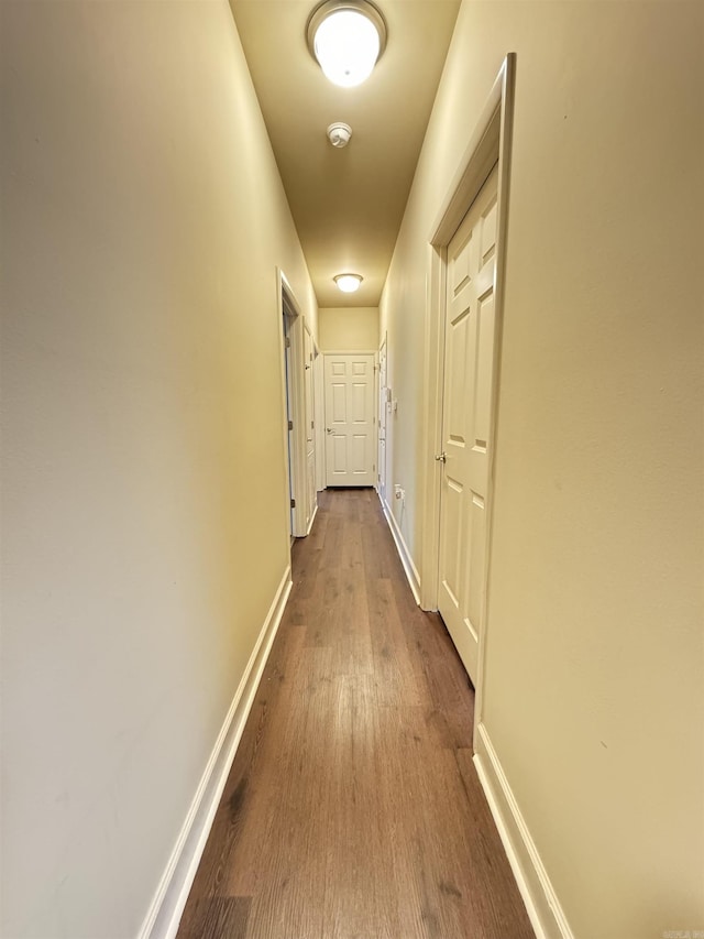 hall with baseboards and dark wood-style floors