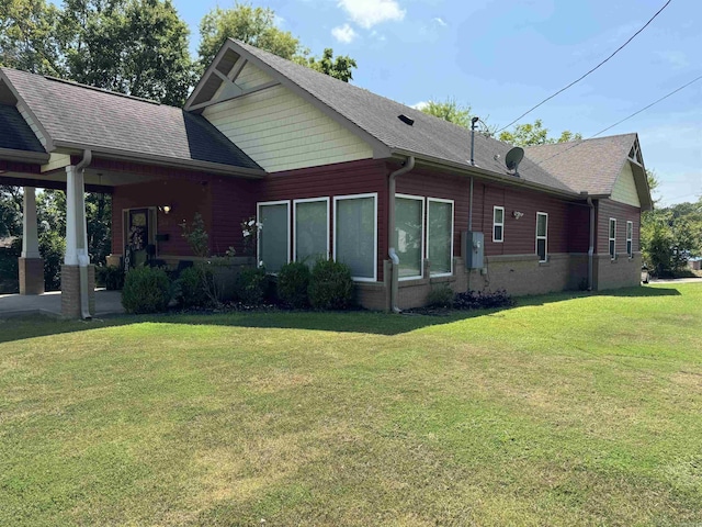 rear view of property with a lawn and a shingled roof