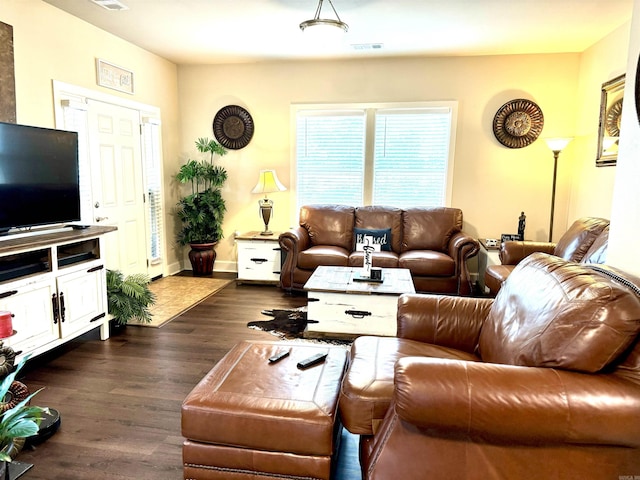 living area featuring baseboards, visible vents, and dark wood-style floors