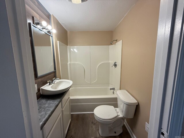 full bathroom with vanity, toilet, a textured ceiling, shower / bath combination, and wood finished floors