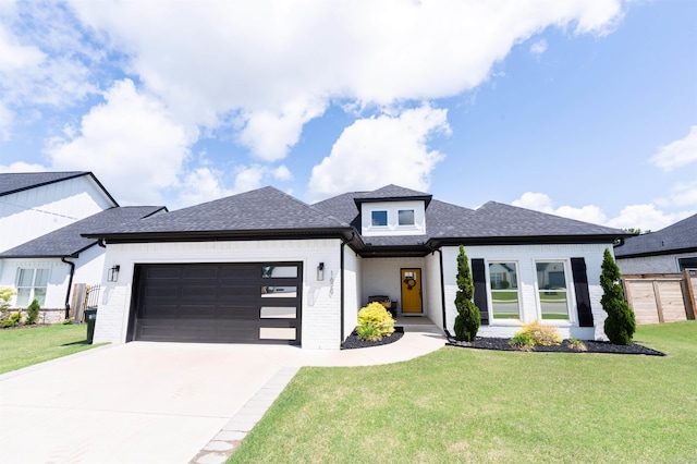 prairie-style home featuring driveway, roof with shingles, brick siding, a front lawn, and an attached garage
