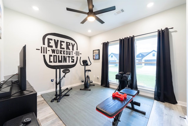 exercise area with baseboards, ceiling fan, visible vents, and wood finished floors