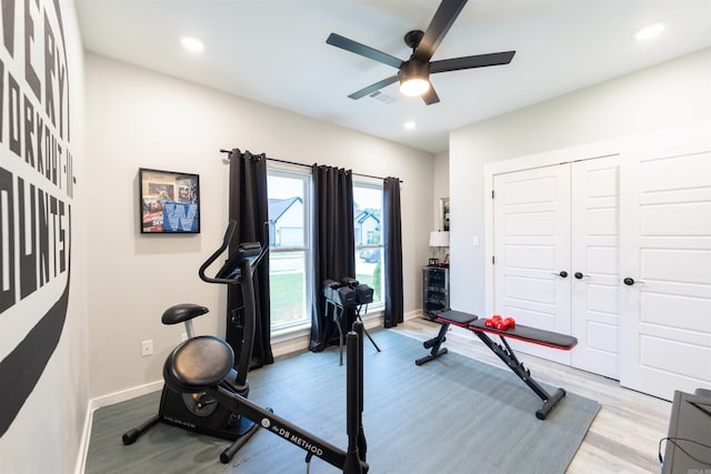 workout room featuring visible vents, light wood finished floors, ceiling fan, and baseboards