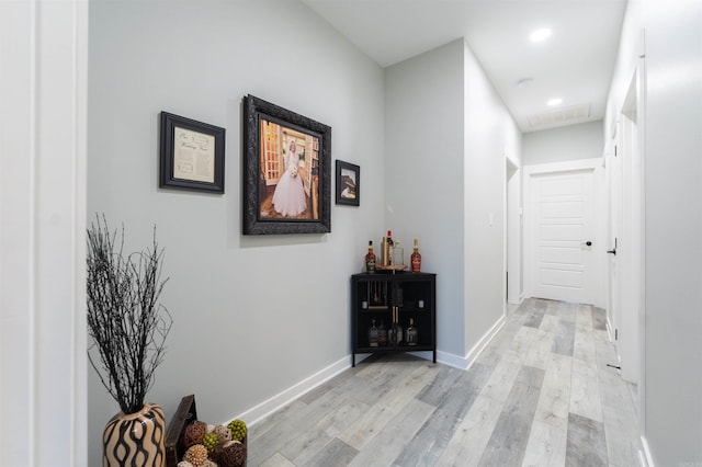 corridor with recessed lighting, light wood finished floors, and baseboards