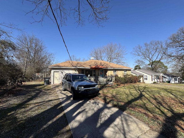 view of front of house featuring a garage, covered porch, driveway, and a front lawn