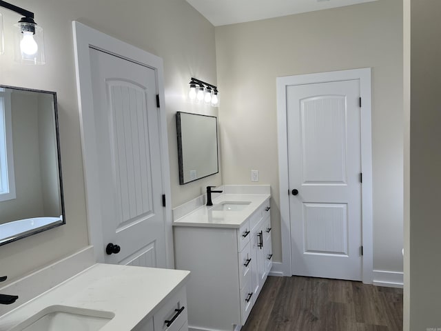bathroom with vanity, baseboards, and wood finished floors