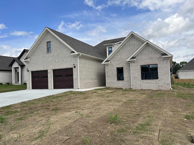 view of front of property featuring brick siding, driveway, and a garage
