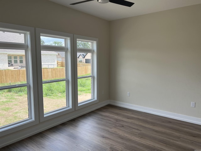 empty room with baseboards, dark wood-style flooring, and ceiling fan