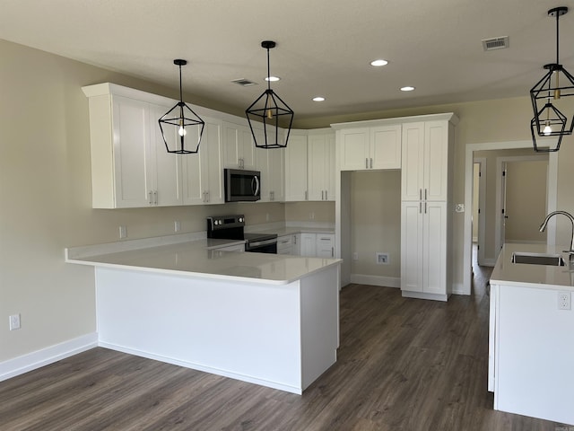 kitchen with dark wood-style flooring, stainless steel appliances, visible vents, and a sink