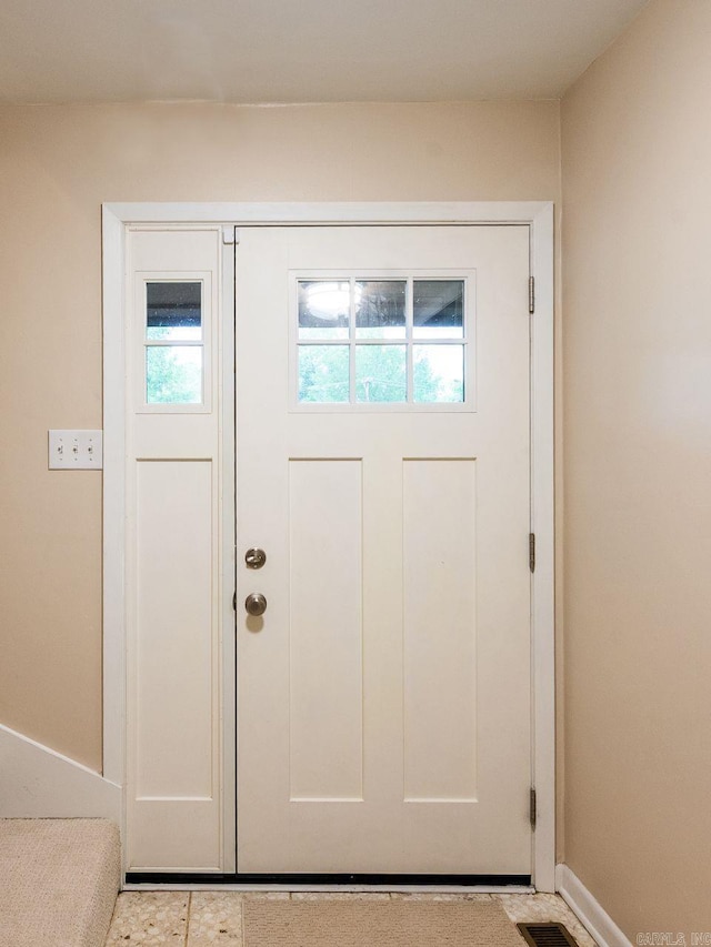 doorway to outside featuring baseboards