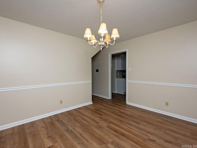 empty room featuring baseboards, wood finished floors, and a chandelier