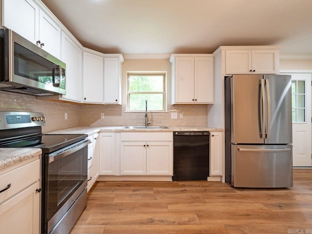 kitchen featuring a sink, appliances with stainless steel finishes, white cabinets, and backsplash