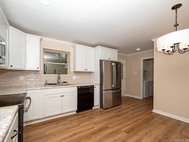 kitchen with washer / clothes dryer, a sink, black appliances, and tasteful backsplash