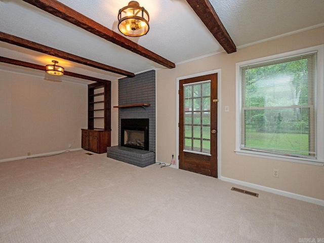 unfurnished living room with carpet floors, a fireplace, beam ceiling, and visible vents