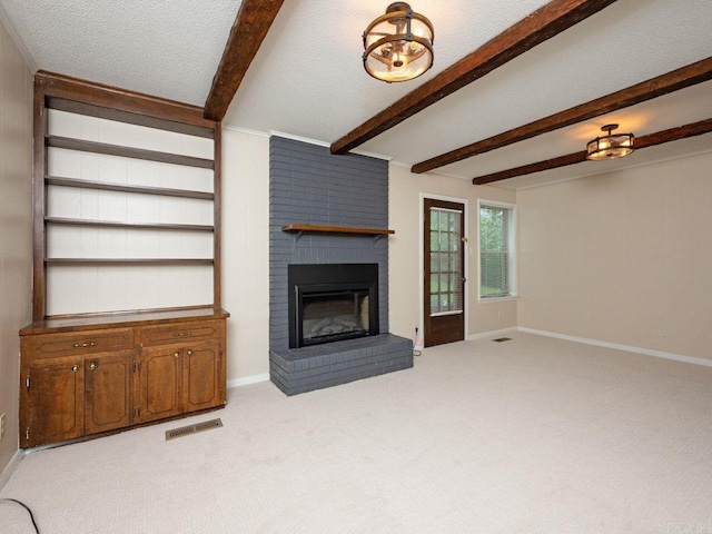 unfurnished living room with visible vents, a fireplace, beam ceiling, baseboards, and light carpet