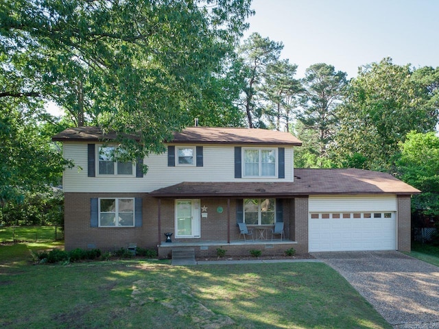 traditional home with covered porch, brick siding, a front yard, and a garage