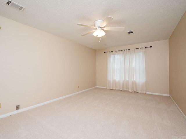 unfurnished room with visible vents, a ceiling fan, baseboards, and light colored carpet