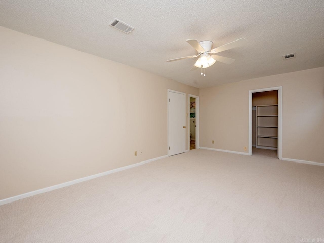 unfurnished room featuring ceiling fan, visible vents, light carpet, and baseboards