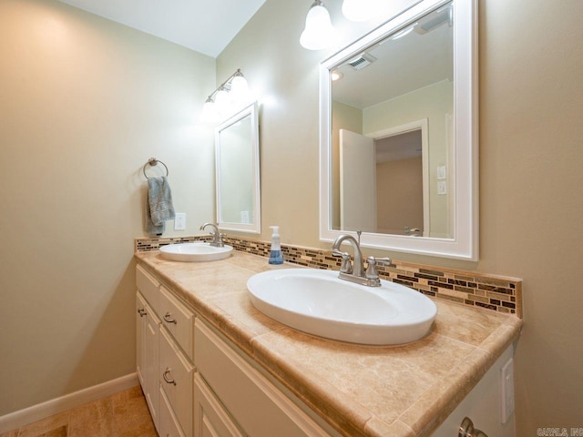 bathroom featuring a sink, tasteful backsplash, double vanity, and visible vents