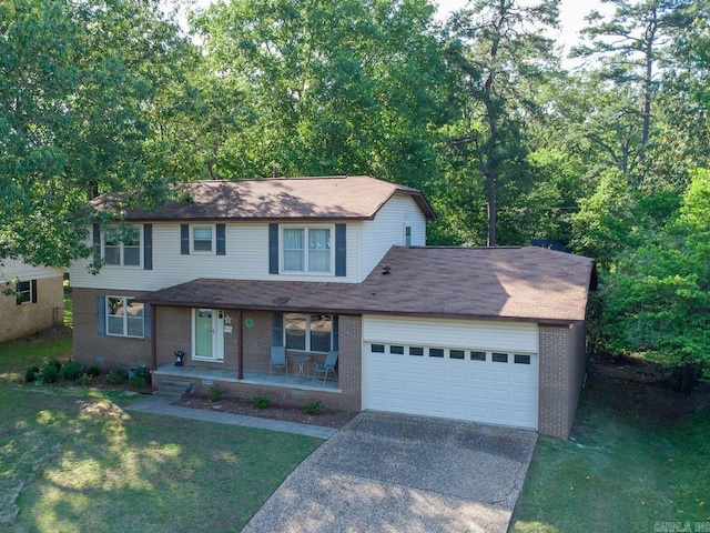 traditional-style house featuring brick siding, an attached garage, covered porch, and concrete driveway