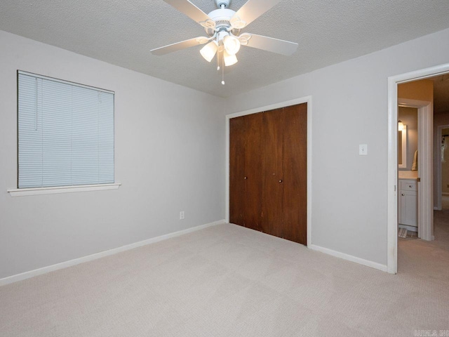 unfurnished bedroom with baseboards, light carpet, ceiling fan, and a closet