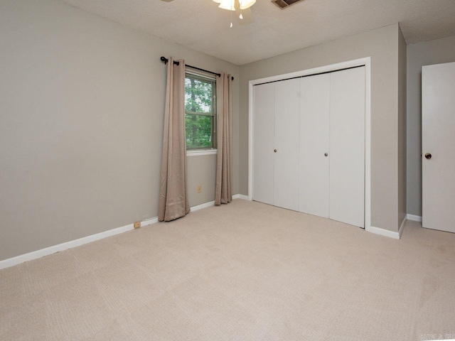 unfurnished bedroom with baseboards, light carpet, and a closet